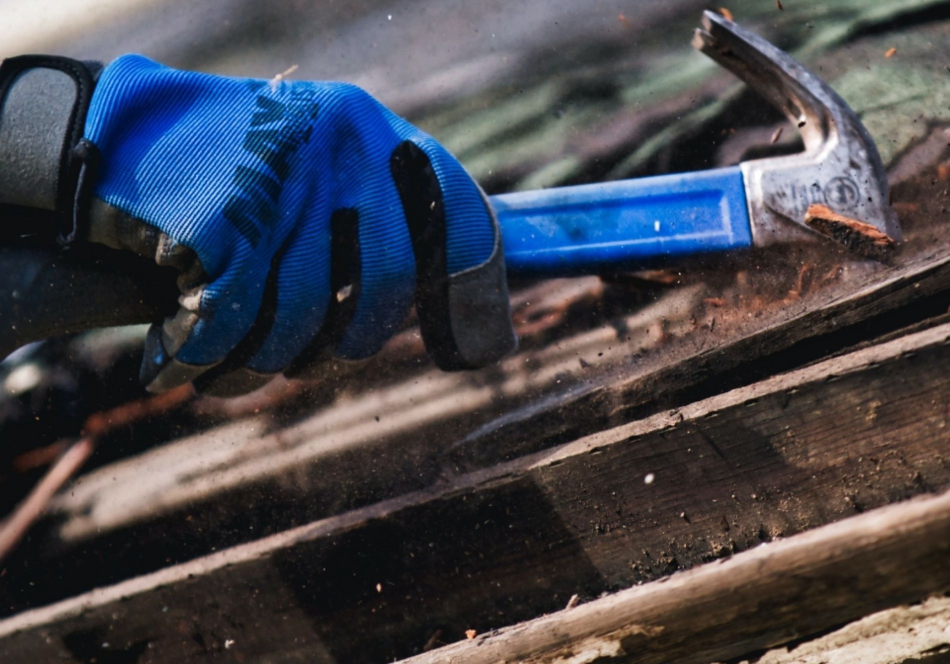 Man fixing roof with hammer